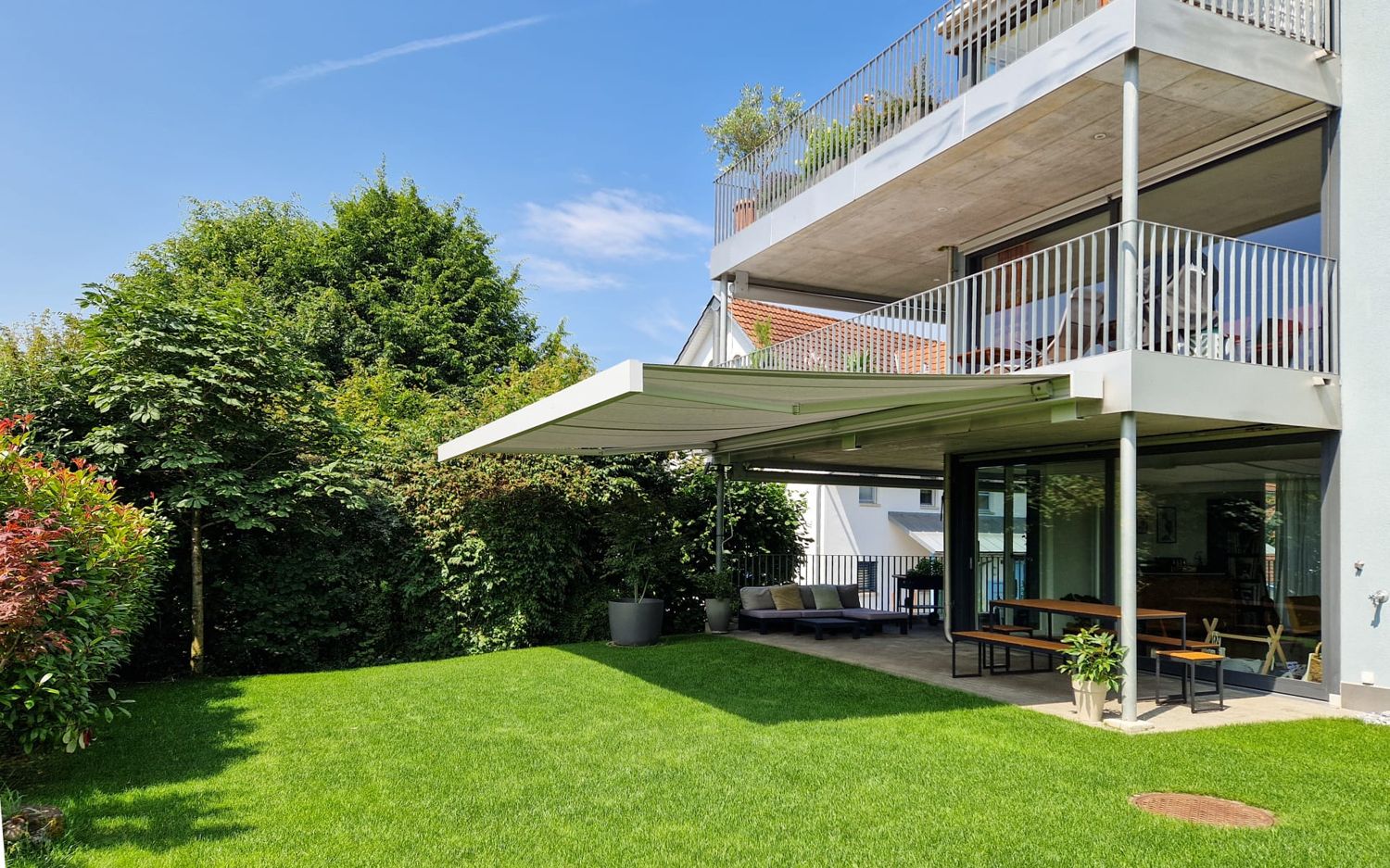 Markise über der Terrasse eines Mehrfamilienhauses