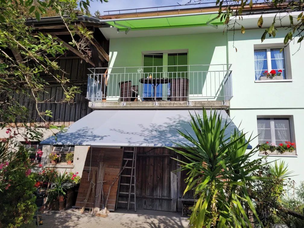 Markise über der Terrasse eines Hauses mit Balkon